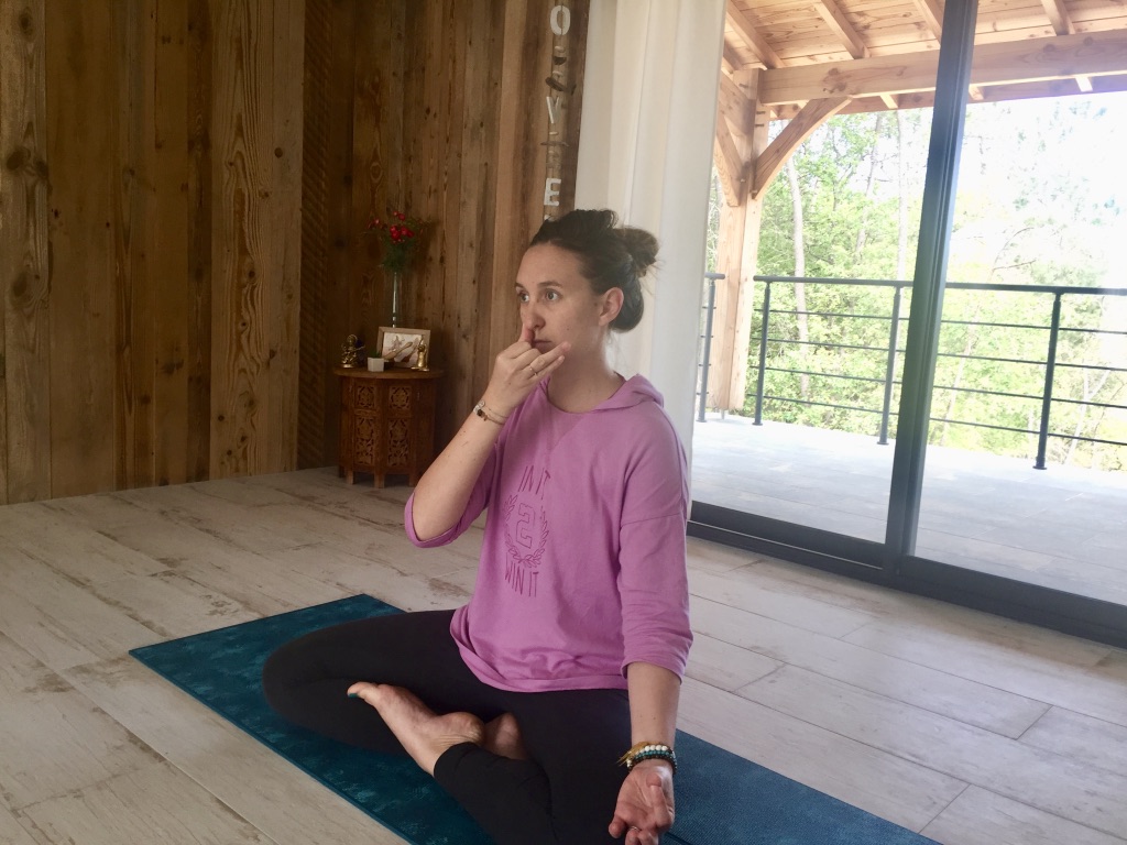 Assise en posture du lotus, pratiquant anuloma viloma ou respiration alternée