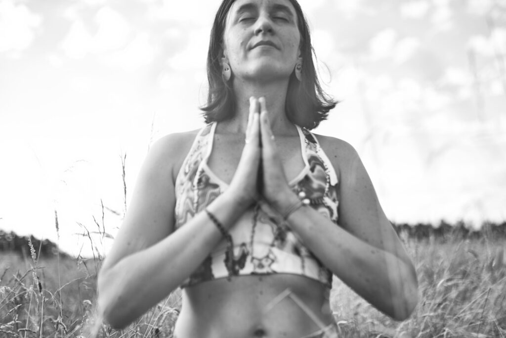 Photo en noir et blanc les maisn en prière et les yeux fermés tête orientée vers le ciel, en méditation